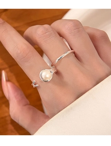 Detailed view of silver double-layered open ring with pearl on model hand