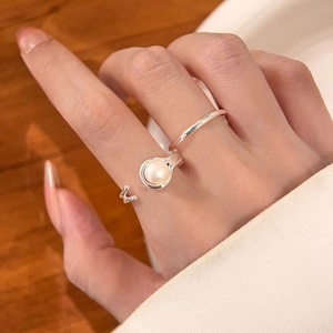 Elegant silver-tone double-line open ring with a cream pearl on a female model finger