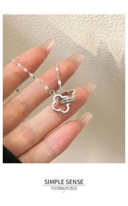 Dettaglio ravvicinato di una collana in argento con quadrifogli intrecciati e zirconi
