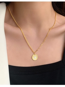 Detail of a gold coin rabbit necklace featuring an asymmetric mixed paperclip chain design