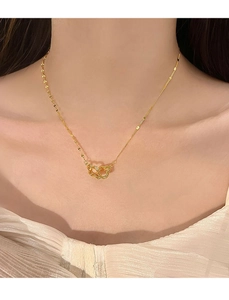 Dettaglio della collana a doppio cuore intrecciato in oro con micro pavé di zirconi su modella