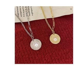 Macro shot of gold and silver rabbit coin pendants on red knit background