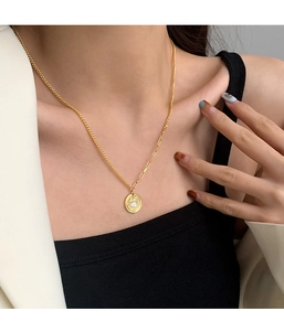 Detail of gold coin necklace with white rabbit pendant and mixed chain link design