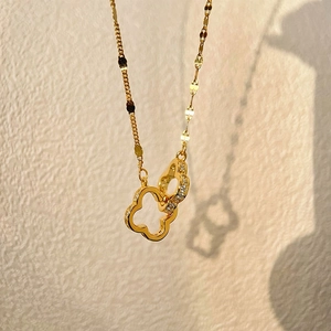 Elegante collana dorata con ciondolo a quadrifoglio intrecciato e cristalli brillanti