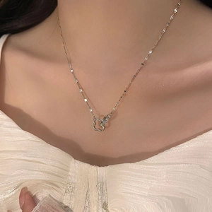 Elegante collana d'argento con fiori intrecciati e anello pavé indossata da modella