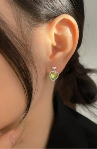 Close-up of Aurora cat-eye heart earring on model with iridescent shimmer and silver finish