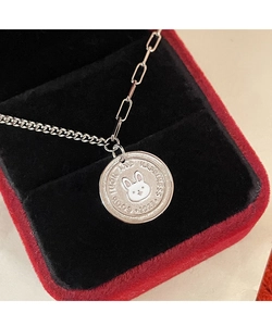 Close-up of silver rabbit coin necklace with luck and happiness engraving in a gift box
