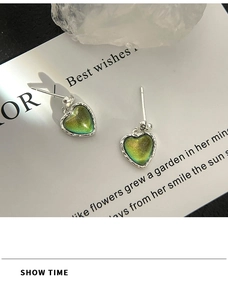 Macro detail of iridescent heart stud earrings with silver rope textured borders
