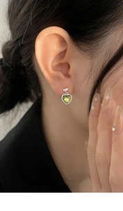 Close-up of aurora cat eye heart earring worn by a model in a minimalist style