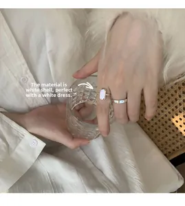 Close-up of shell inlay ring and slim silver band worn together for an elegant look