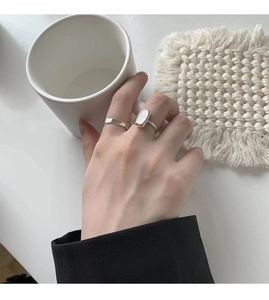 Detailed view of silver stackable rings featuring a rectangular shell inlay on the finger
