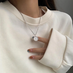 Silver rabbit coin pendant necklace with asymmetric chain on white knit sweater