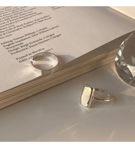 Detail of silver shell rings set with geometric design and iridescent shell inlay