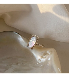 Macro detail of silver ring featuring iridescent rectangular mother of pearl inlay