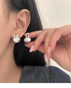 Gros plan de boucles d'oreilles lapin en argent S925 avec motif matelassé sur l'oreille