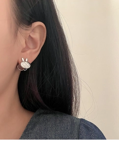 Gros plan sur les boucles d'oreilles lapin en argent S925 avec motif de texture matelassée