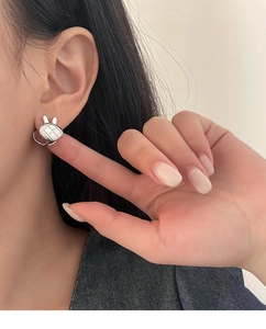 Gros plan d'une boucle d'oreille lapin en argent S925 avec motif losange sur l'oreille