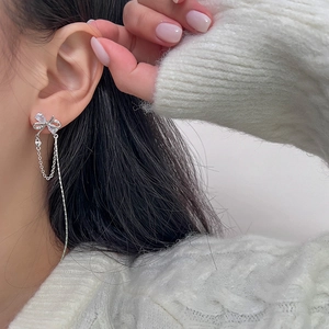 Elegant silver bow tassel earrings with sparkling rhinestones worn by a model