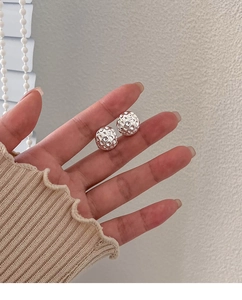 Détail de boucles d'oreilles lave en argent avec texture martelée à la main