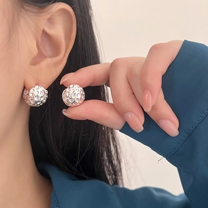 Boucles d'oreilles sphériques argentées à texture de lave portées par un mannequin