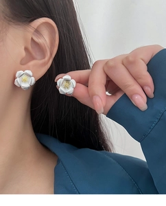 Gros plan détaillé d'un clou d'oreille gardénia en argent avec pétales texturés et centre doré