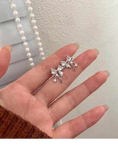 Sparkling silver bow knot earrings with dangling star tassels and clear zircon stones