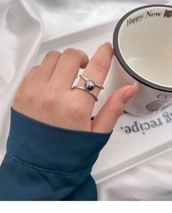 Detail of silver open ring with dark grey pearl on index finger for elegant style