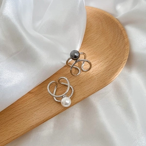 Elegant silver open ring featuring overlapping white and grey pearls on silk cloth
