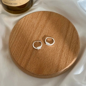 Elegante s925 sterling zilveren oorringen met drievoudige ringen op gepolijst hout en zijde
