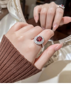 Detailed view of a vintage silver ring with a large oval red gemstone and white crystals
