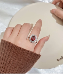 Detailed view of a vintage floral ring featuring a large red oval gemstone and white diamonds