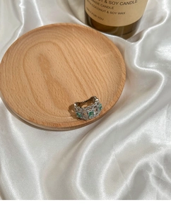 Detail showing vintage silver-tone woven ring with emerald green gems and zircon accents