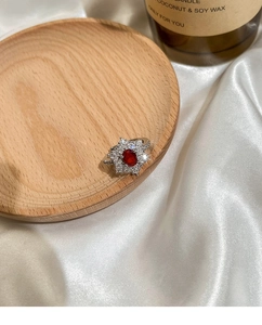 Detailansicht eines Rubin-Blumenrings auf Holz- und Seidenhintergrund