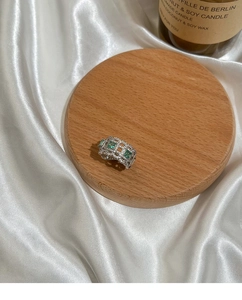 Detailed view of vintage hollow silver ring with emerald gemstones and white cubic zirconia