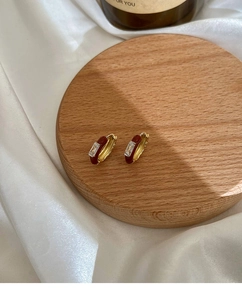 Detalle de pendientes de lujo con esmalte rojo oscuro y cristal de circón rectangular