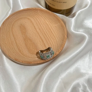 Vintage silver hollow lace ring with emerald green zircon gemstone on white silk