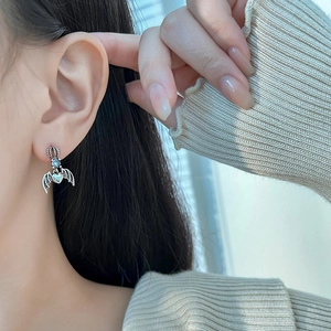 Gothic crown heart wing earrings in vintage silver on model for a sweet cool style