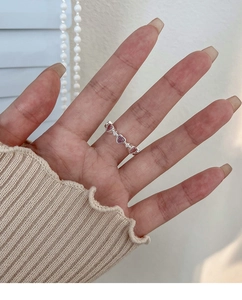 Close-up of heart-shaped pink crystals and micro diamonds on a silver metal ring