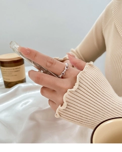 Close-up of model wearing silver ring with pink heart stones and soft aesthetic lifestyle decor