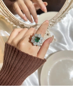 Gros plan sur la bague fleur luxe vert émeraude avec pétales en zircon blanc