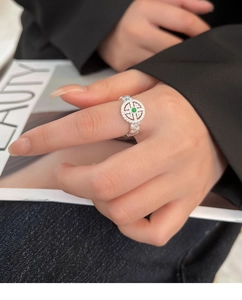 Detail of lace silver ring featuring a green gemstone and sparkling zircon pave setting