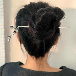 Elegant plum blossom silver hair stick shown on a model with classic hair styling