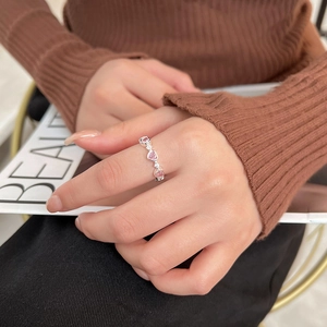 Elegant silver ring with pink heart zircons and white crystals worn by a model