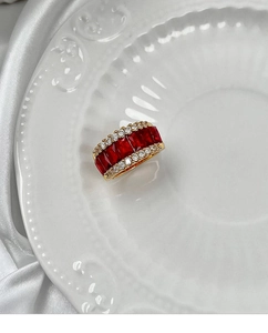 Macro d'une bague dorée avec cinq pierres rouges rectangulaires et pavé de diamants