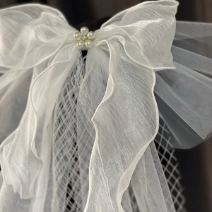 Elegante witte bruidsstrik met parelbloem en transparante organza lagen tule