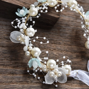 Détail macro du bandeau fait main avec perles et fleurs bleues sur bois vintage