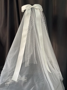 Elegant white bridal veil with large satin bow and lace flower details for weddings