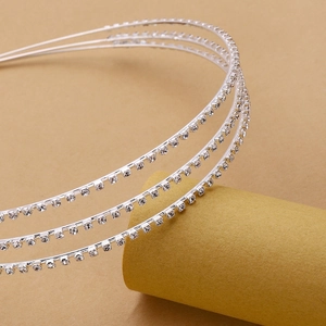 Macro shot of silver triple-layered headband with sparkling rhinestones on golden stand