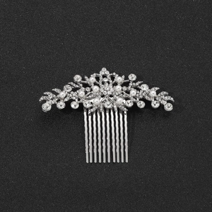 Dettaglio del pettine per capelli in argento con eleganti strass e perle bianche