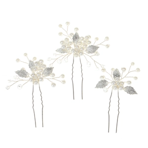 Dettaglio di tre forcine per capelli in argento con perle bianche e foglie incise